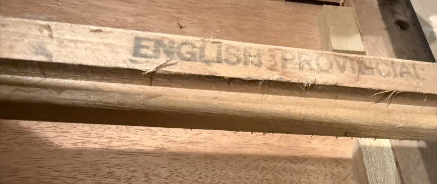 The words English Provincial stamped on a drawer rail inside a table